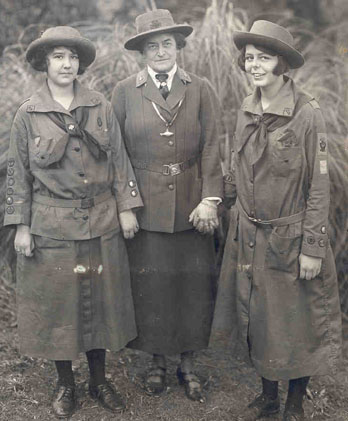 Juliette Gordon Low (center) standing with two Girl Scouts